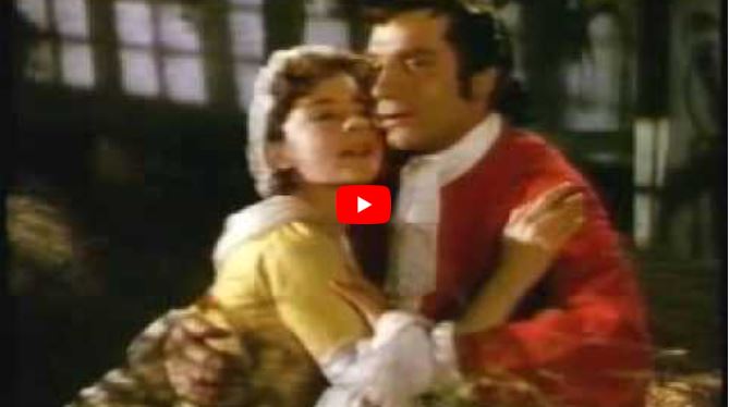 A man in a red coat embraces a woman in a yellow dress and white bonnet, evoking the dramatic romance of operas set in London.
