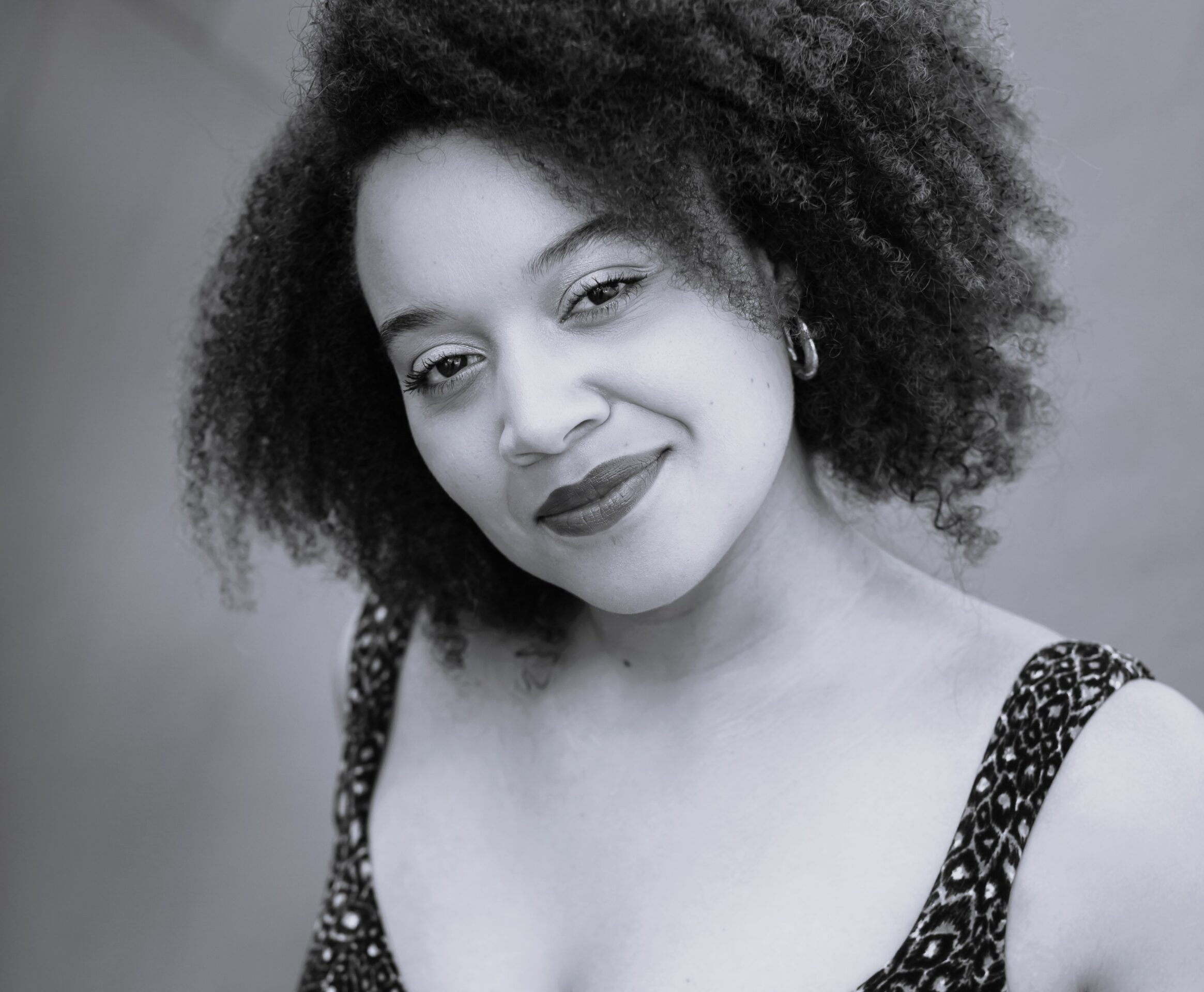Black and white headshot of Taylor Raven smiling.