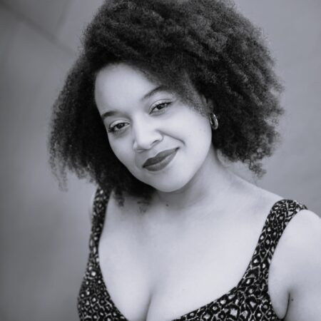 Black and white headshot of Taylor Raven smiling.