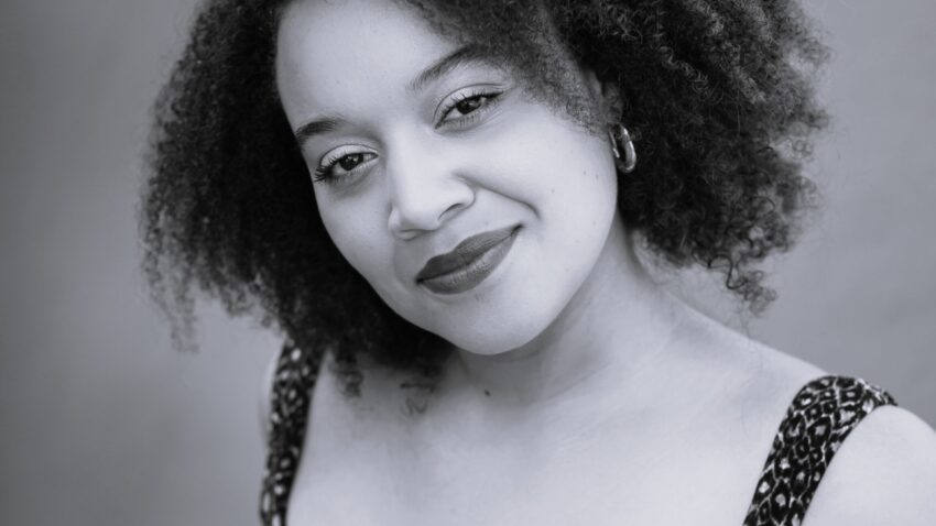 Black and white headshot of Taylor Raven smiling.