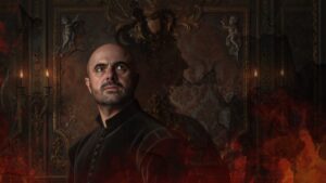 A serious, bald man in dark clothing stands in front of an ornate, dimly lit wall with candles and cherub statues, surrounded by shadows and red-orange flames.