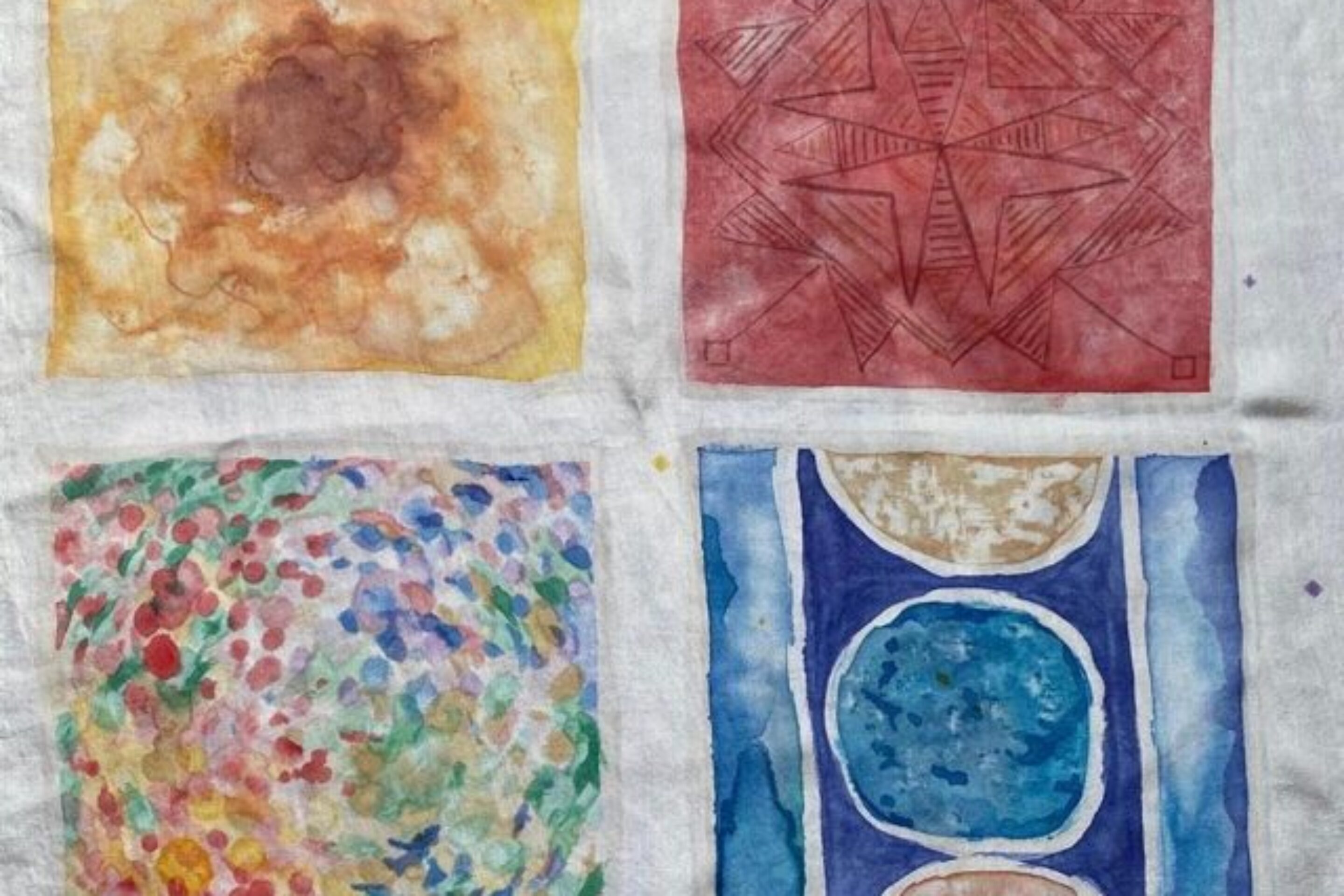 Four watercolour paintings on white fabric: top left is a brown and yellow abstract; top right is a red geometric star pattern; bottom left has colourful dots; bottom right shows blue and brown circles with vertical blue lines.