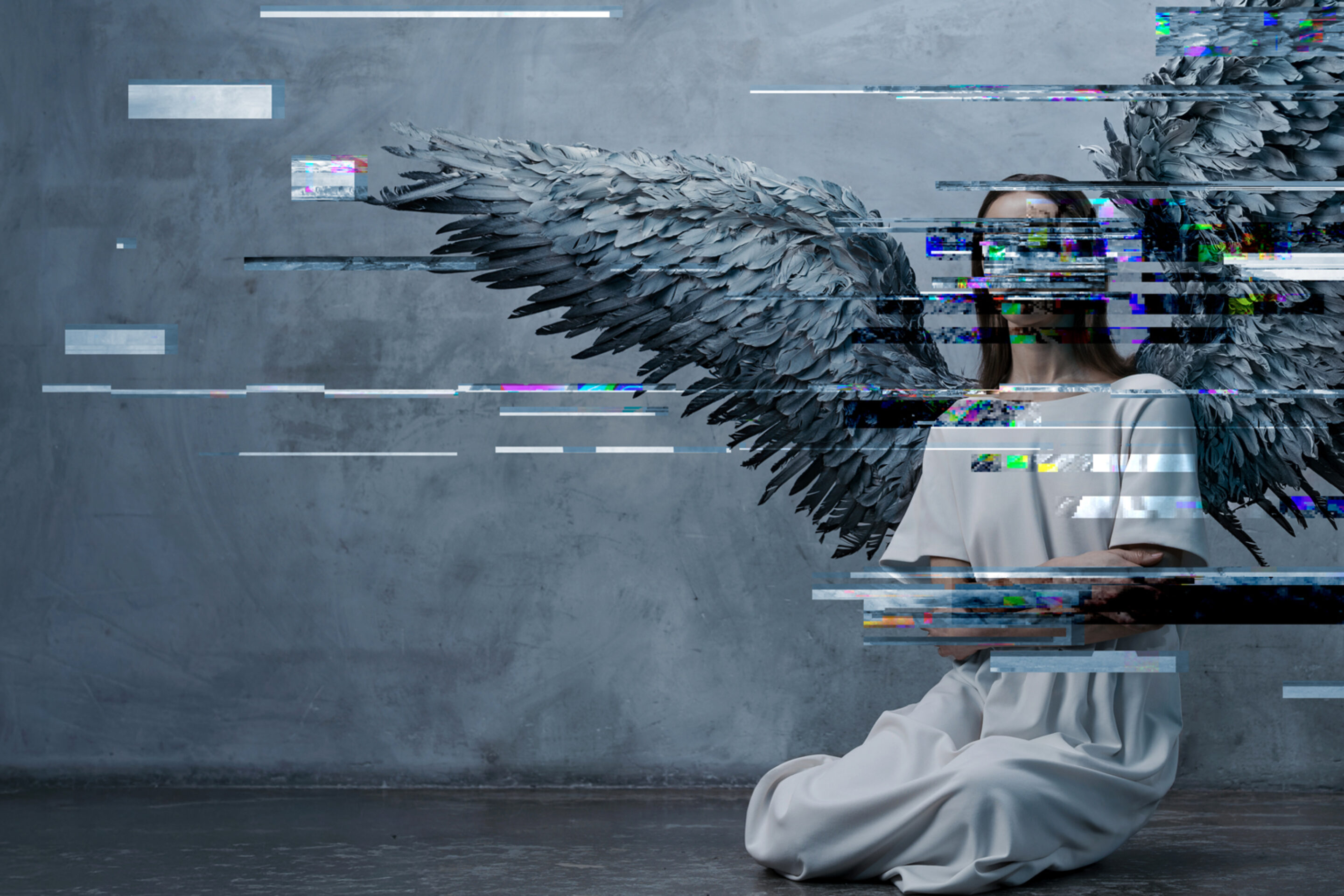 A woman in a white dress kneels on the floor with large, dark angel wings against a grey wall. Digital glitch effects obscure parts of her body and wings, evoking the haunting atmosphere of Du Yun and Royce Vavrek’s Angel’s Bone.