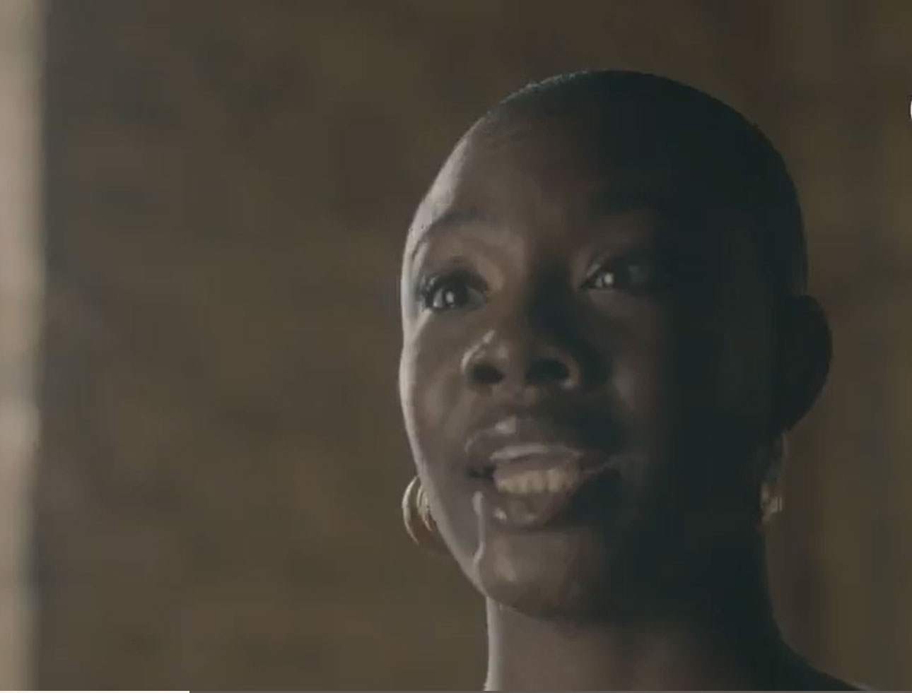 Yomi Adegoke, a person with dark skin and short hair is speaking and wearing hoop earrings. The softly lit, blurred background sets the mood. The white ENO logo appears in the upper right corner, hinting at the excitement of the 2026–27 Season.