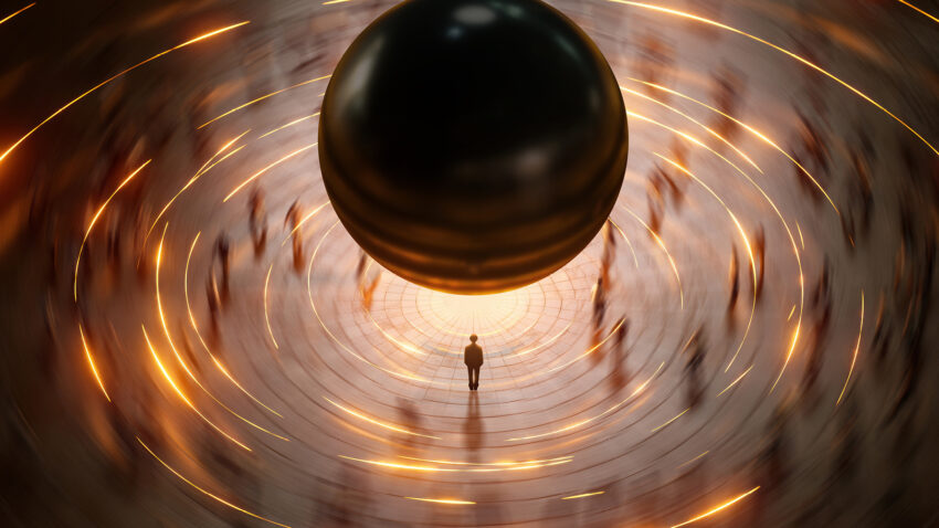 A lone figure stands in the centre of a circular plaza beneath a large, floating dark sphere, surrounded by blurred silhouettes moving in a glowing, orange-lit ring.