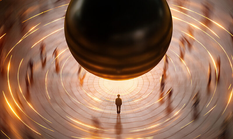 A small person stands in the centre of a circular plaza, looking up at a massive, hovering black sphere from Einstein on the Beach, surrounded by streaks of golden light and blurred figures.