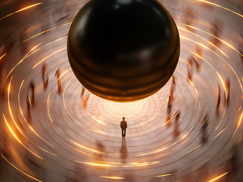 A small person stands in the centre of a circular plaza, looking up at a massive, hovering black sphere from Einstein on the Beach, surrounded by streaks of golden light and blurred figures.